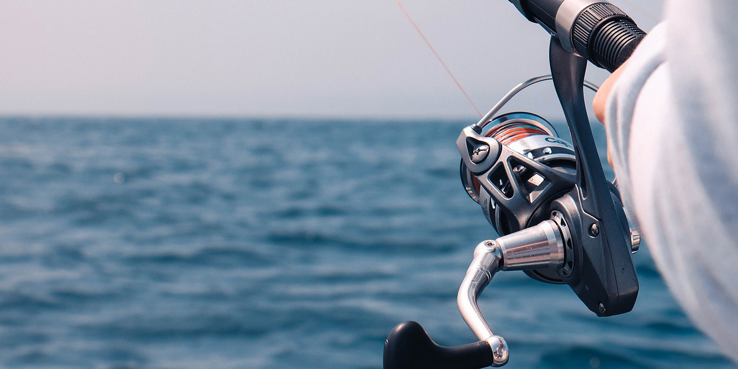 Close up of spool of someone fishing in the ocean